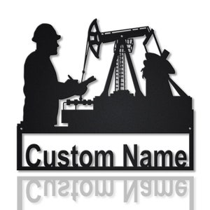 May include: Black metal wall art featuring a silhouette of an oil worker, an oil pump jack, and an oil derrick. The words "Custom Name" are displayed in a bold font. The artwork is designed to be personalized.