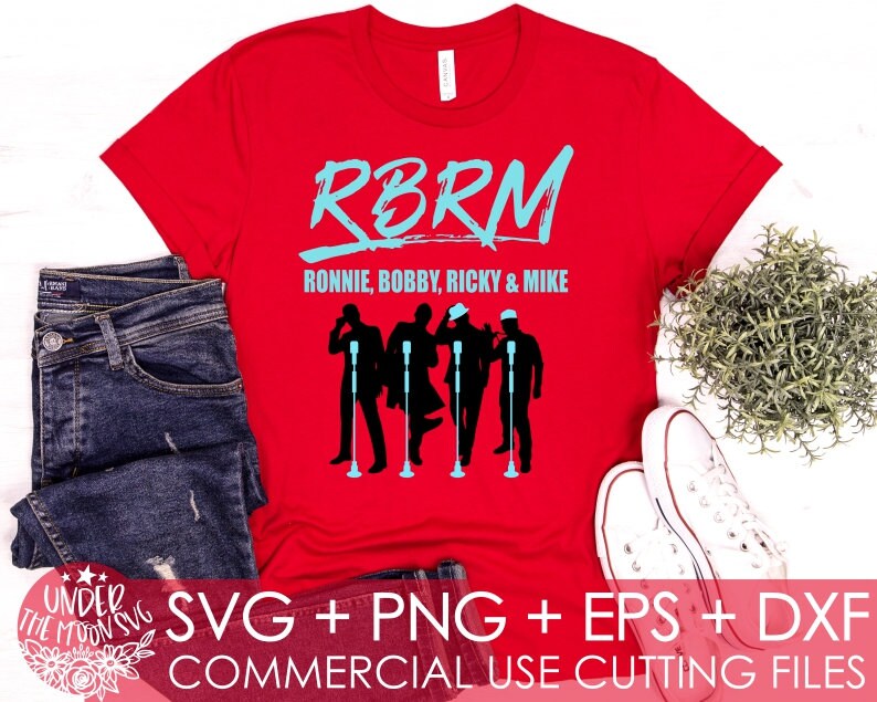 May include: Red t-shirt with a blue graphic of four singers with microphones. The text "RBRM" and "Ronnie, Bobby, Ricky & Mike" is printed on the shirt. The shirt is on a white surface with a pair of blue jeans and a potted plant.