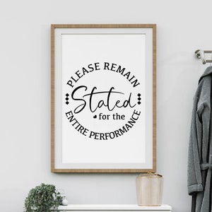 May include: A framed print with a black and white design that says "Please remain seated for the entire performance".