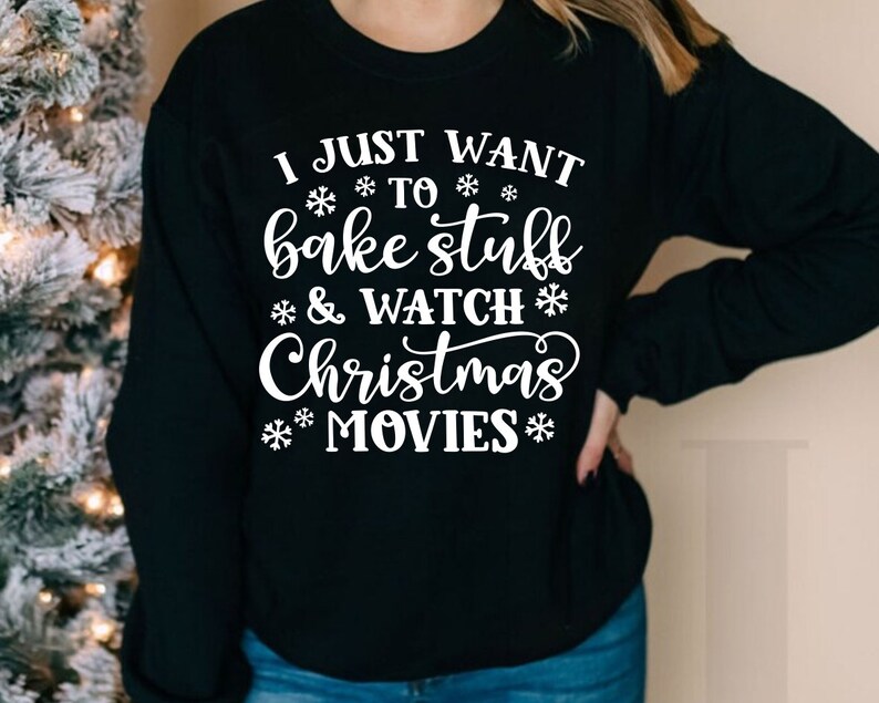 May include: Black sweatshirt with white text that reads "I just want to bake stuff & watch Christmas movies". The text is surrounded by snowflakes.