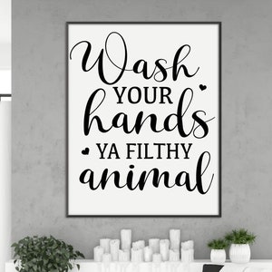 May include: A black and white sign with the text "Wash your hands ya filthy animal" in a cursive font.