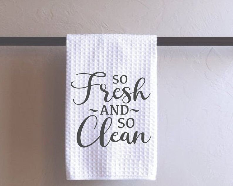 May include: White kitchen towel with the text "So Fresh And So Clean" printed in black.