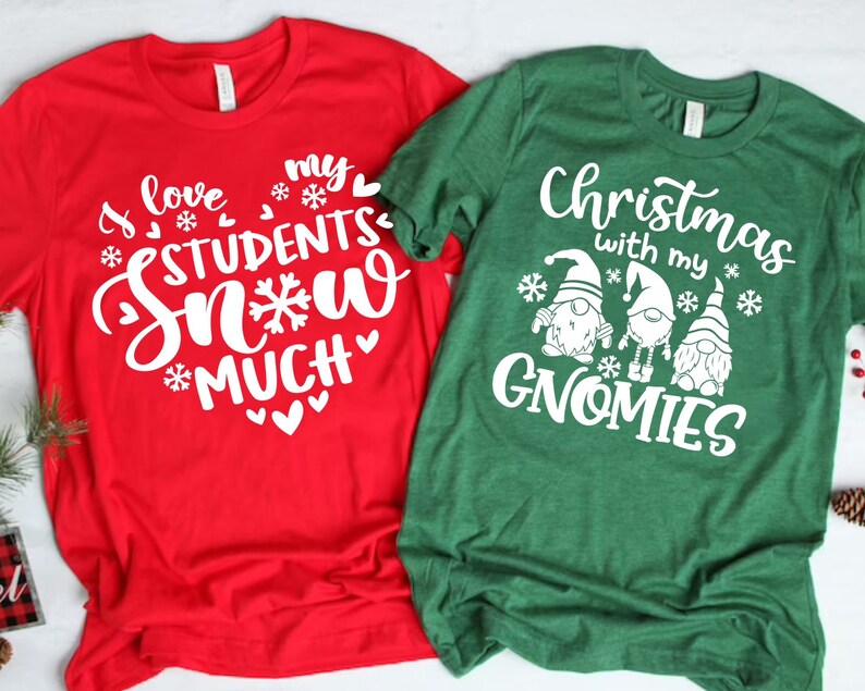 May include: Two Christmas themed t-shirts. The red shirt says "I love my students snow much" with snowflakes and hearts. The green shirt says "Christmas with my gnomes" with three gnomes and snowflakes.