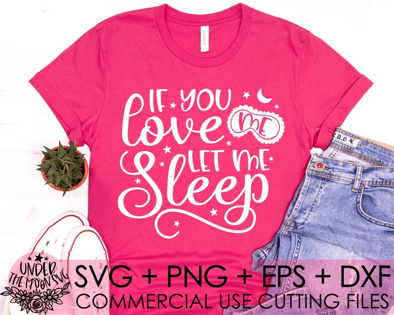 Puede incluir: Una camiseta rosa con el texto "If you love me let me sleep" en blanco. El texto est&aacute; en una fuente cursiva e incluye una peque&ntilde;a estrella y una luna creciente. La camiseta est&aacute; colocada sobre una superficie blanca con un par de zapatillas blancas y un par de pantalones vaqueros azules.