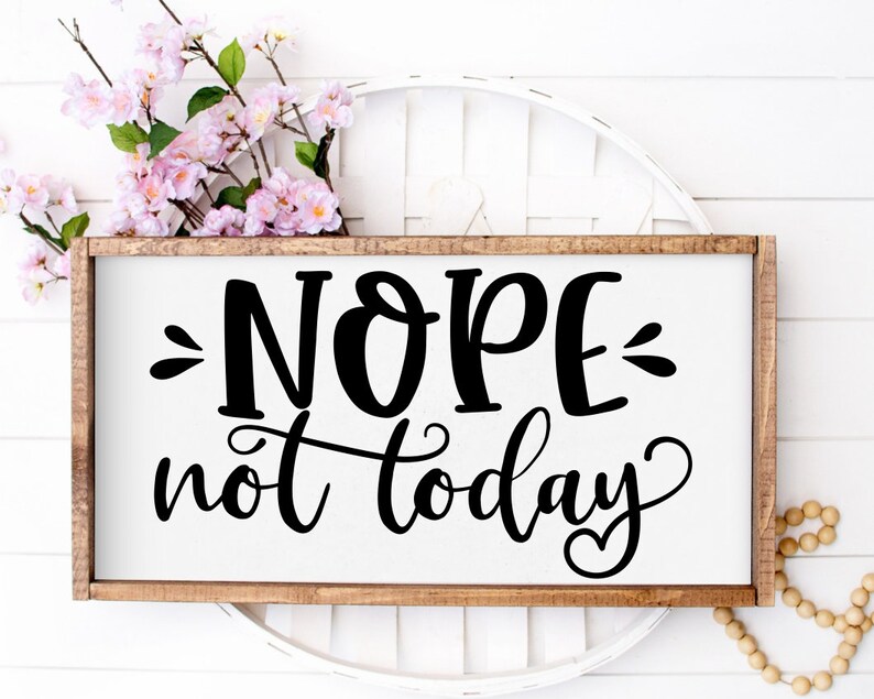 Puede incluir: Un letrero de madera con el texto "NOPE not today" en letras negras sobre fondo blanco. El letrero est&aacute; sobre una superficie de mimbre blanca.