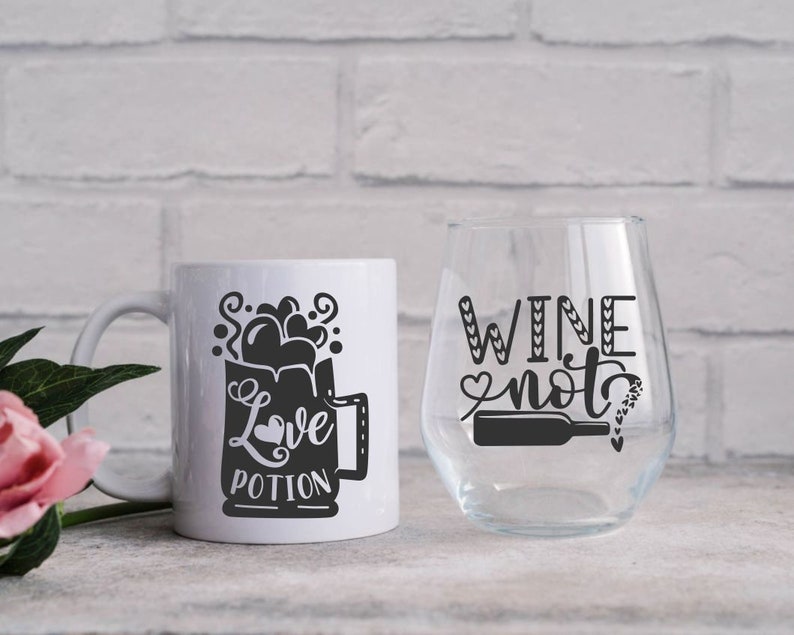 May include: White ceramic mug with a black graphic of a mug with the text "Love Potion" and a white wine glass with the text "Wine not" in black.