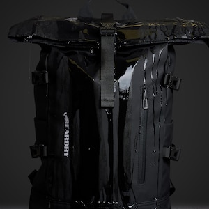 Op de afbeelding: Zwarte waterdichte rugzak met een oprolbare sluiting en meerdere gespriemen. De rugzak heeft een zijvak met ritssluiting en de merknaam "BEARDRY" is erop gedrukt. Waterdruppels zijn zichtbaar.