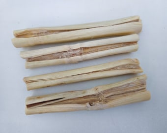 May include: Four natural, light brown, split bamboo sticks, arranged in a row on a white surface.