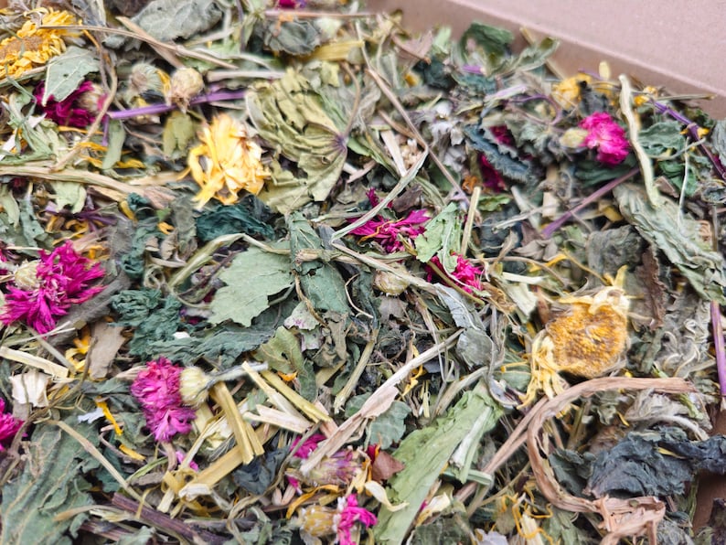 K&ouml;nnte beinhalten: Nahaufnahme einer Mischung aus getrockneten Kr&auml;utern und Bl&uuml;ten, darunter gr&uuml;ne Bl&auml;tter, gelbe Bl&uuml;tenbl&auml;tter und rosa Bl&uuml;ten.