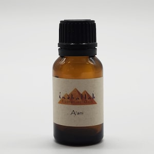 May include: A brown glass essential oil bottle with a black cap. The label reads "inshallah Essential Oils" above the word "A'ani". The bottle has a light brown label and a dark brown liquid inside.