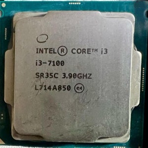 Może przedstawiać: Zbliżenie na srebrny procesor Intel Core i3-7100 z nadrukowanym tekstem "SR35C 3.90GHz L714A850".