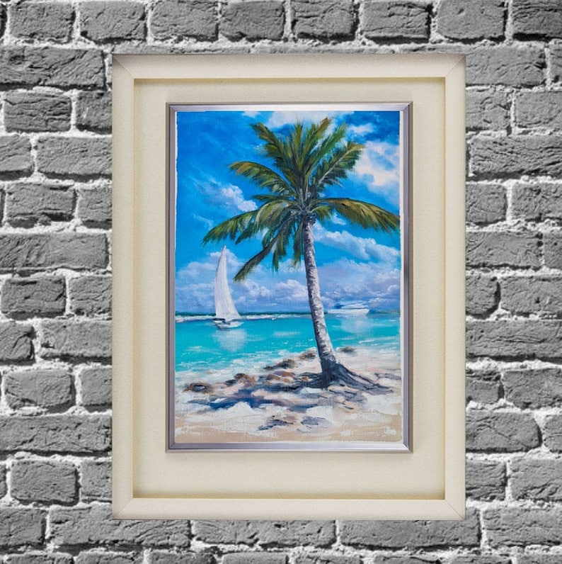Puede incluir: Una pintura enmarcada que representa una escena de playa tropical con una palmera y un velero en la distancia. La pintura est&aacute; realizada en un estilo realista con colores vibrantes.