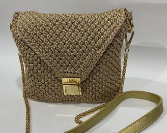 May include: A gold crocheted crossbody bag with a gold chain strap and a gold clasp closure.