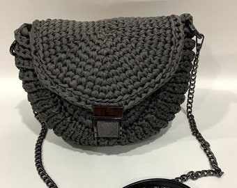 May include: A gray crocheted crossbody bag with a black chain strap and a black leather shoulder strap.