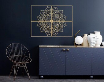 May include: A dark blue cabinet with two doors and gold knobs. The cabinet is decorated with a gold mandala design on the wall behind it. There is a chair and a lamp on the table in front of the cabinet.