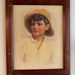 May include: A framed portrait of a young person wearing a tan hat and a light-colored shirt. The portrait is in a dark brown wooden frame. The artist's signature, "Florence Vine", is visible in the lower right corner.