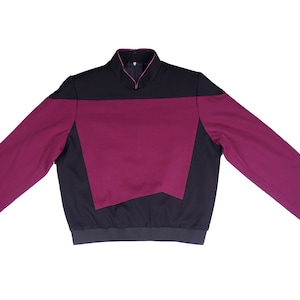 May include: A long-sleeved shirt with a black collar and a burgundy and black colour block design.