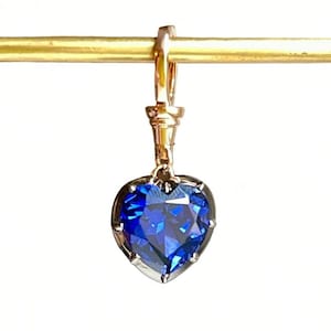 Peut inclure: Un pendentif en forme de cœur avec une grosse pierre de saphir bleue sertie d'or.