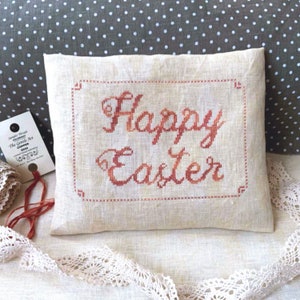 May include: A white linen pillow with a red embroidered message that says "Happy Easter".