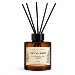 May include: A 100ml amber glass reed diffuser bottle with a black cap and five black reeds. The cream-colored label reads: COSY ART LONDON, KEW GARDEN, EUCALYPTUS & MINT DIFFUSER, 100ml, ESSENTIAL OILS INFUSED, featuring botanical illustrations on the sides.