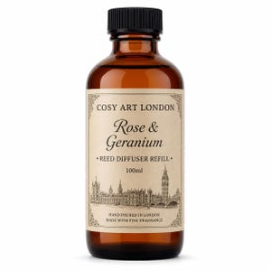 Könnte beinhalten: Eine 100ml Braunglasflasche mit schwarzem Schraubverschluss, die eine Nachfüllung für einen Raumduft enthält. Das Etikett zeigt den Text COSY ART LONDON, Rose & Geranium, REED DIFFUSER REFILL, 100ml und eine schwarz-weiße Illustration der Skyline von London.