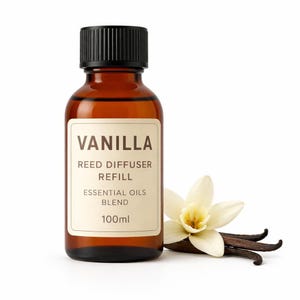 Puede incluir: Un frasco de vidrio ámbar de 100ml con tapa negra que contiene un recambio de difusor de varillas de vainilla. La etiqueta dice VANILLA REED DIFFUSER REFILL ESSENTIAL OILS BLEND 100ml. Una flor de vainilla blanca y vainas oscuras al lado.