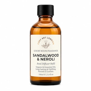 May include: An amber glass bottle with a black cap containing 3.4 fl oz of reed diffuser refill. The white label reads Cosy Art London Luxury Room Fragrance Sandalwood & Neroli, Reed Diffuser Refill, Organic & Essential Oils, Long Lasting & Uplifting.