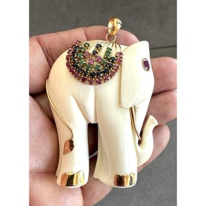 De mooiste, ENORME, gebeeldhouwde olifantenhanger van 14 karaats goud, 7 cm lang, met een deken van robijnen, smaragden en saffieren.