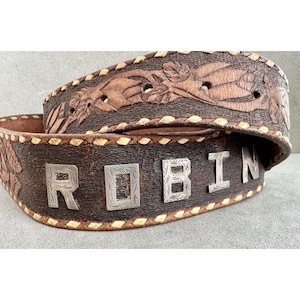 Puede incluir: Una taza de cer&aacute;mica blanca con un asa negra y el texto "But First, Coffee" en negro y negrita. La taza est&aacute; sobre una superficie de madera. La taza mide aproximadamente 10 cm de alto.