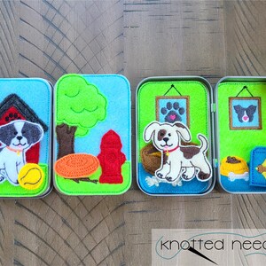 May include: Four small tin boxes with felt appliques of a dog in different scenes. The first box shows a dog in a red doghouse with a yellow ball. The second box shows a dog in front of a green tree and a red fire hydrant. The third box shows a dog in a green room with a picture on the wall. The fourth box shows a dog in a green room with a picture on the wall and a blue and yellow dog bed.