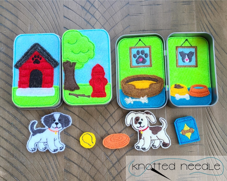 May include: Felt play set with a dog house, a fire hydrant, a dog bed, a dog bowl, a bone, and two dogs. The set is in a tin box with a green background and blue trim. The dogs are white with black spots.