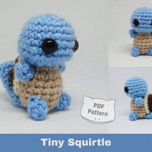 May include: A crocheted Squirtle plush toy in blue, brown, and beige. The toy is sitting on a white surface. The text "PDF Pattern" is visible in the image.