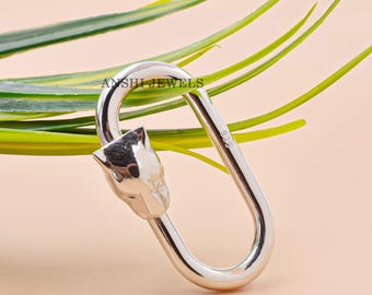 May include: Silver-toned metal key chain with a panther head design. The key chain is oval shaped and has a clasp.