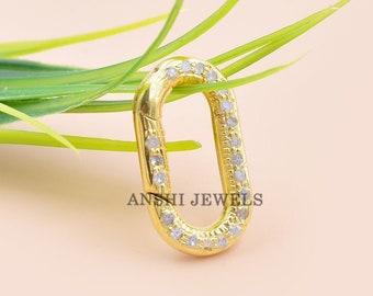 Puede incluir: Cierre ovalado de color dorado con piedras de circonita cúbica transparentes engastadas en el perímetro. ANSHI JEWELS está impreso en la parte inferior del cierre.