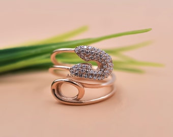 Anillo de plata 925 con circonita cúbica blanca y diseño de imperdible.