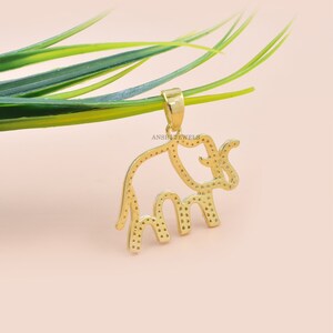 Op de afbeelding: Een gouden olifantenhanger met een gedetailleerde omtrek en een gestructureerd oppervlak. De hanger hangt aan een ketting en is klaar om als ketting te worden gedragen.