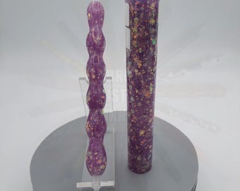 May include: A purple diamond painting pen with a matching storage tube. The pen has a bulbous design with gold glitter accents. The tube is cylindrical and also features purple glitter.
