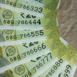 May include: A fan of Indian twenty-rupee banknotes, showing the denomination in the top right corner. The notes feature Mahatma Gandhi's portrait and the Reserve Bank of India seal. Serial numbers are visible on each bill.