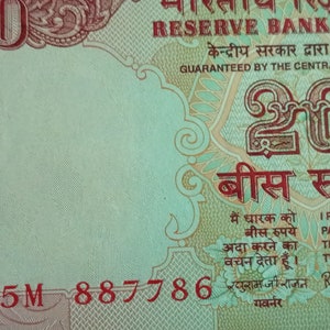 May include: A detailed view of an Indian 20 Rupee banknote. The note displays the text "Reserve Bank of India" and "I promise to pay the bearer the sum of twenty rupees". The number 20 is clearly visible.