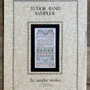 May include: A cross-stitch pattern titled "Tudor Band Sampler" with a black frame. The sampler features intricate designs in red, green, and brown on a white background. The text "the samplar workes" and address are at the bottom.