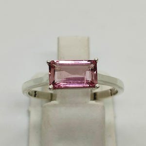 Könnte beinhalten: Ein Set aus drei Keramikbechern mit gesprenkelter, matter Oberfläche. Die Becher sind in Creme-, Hellgrau- und Dunkelgrautönen gehalten. Jeder Becher hat ein schlichtes, minimalistisches Design.