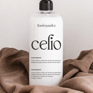 May include: White bottle with a black pump top and label. The label says "flawlessandco" and "celio". The bottle is sitting on a brown fabric surface. The label also includes the text "Lorem ipsum" and a short paragraph of text.