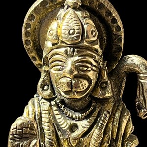 Puede incluir: Una estatua de metal dorado de una deidad hindú con una corona y un halo. La estatua está intrincadamente detallada y tiene una expresión serena.