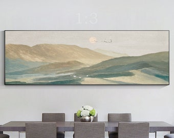 May include: A panoramic landscape painting of a mountain range with a sun setting behind the peaks. The painting is in shades of brown, green, and blue, and is framed in a black frame. The painting is hanging on a white wall above a dining table with six chairs.