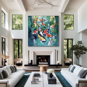 May include: Large abstract painting of koi fish in a pond. The artwork features vibrant orange, yellow, and white fish against a textured teal and green background. The painting is displayed in a modern living room with white walls and furniture.