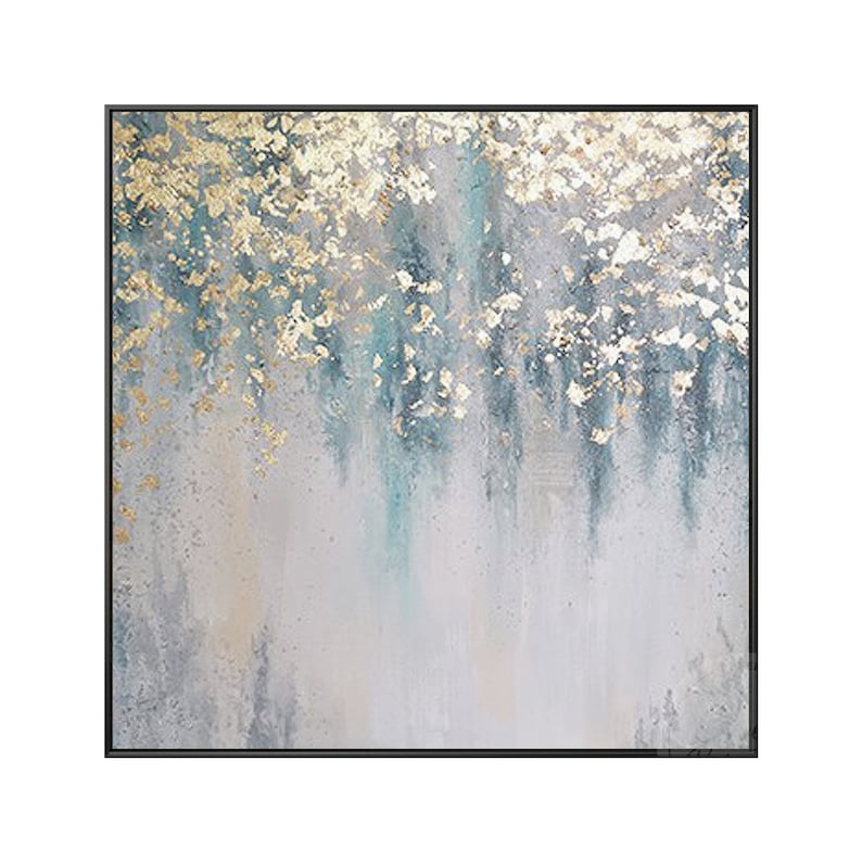 Op de afbeelding: Abstract schilderij met een grijze achtergrond en gouden en turquoise accenten. Het schilderij heeft een textuur en is ingelijst in een zwart frame.