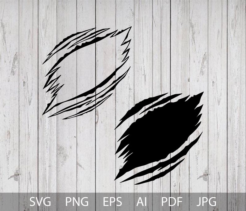 May include: Two black ripped or torn shapes, one with a white interior and the other with a black interior. The shapes are on a white wood background.