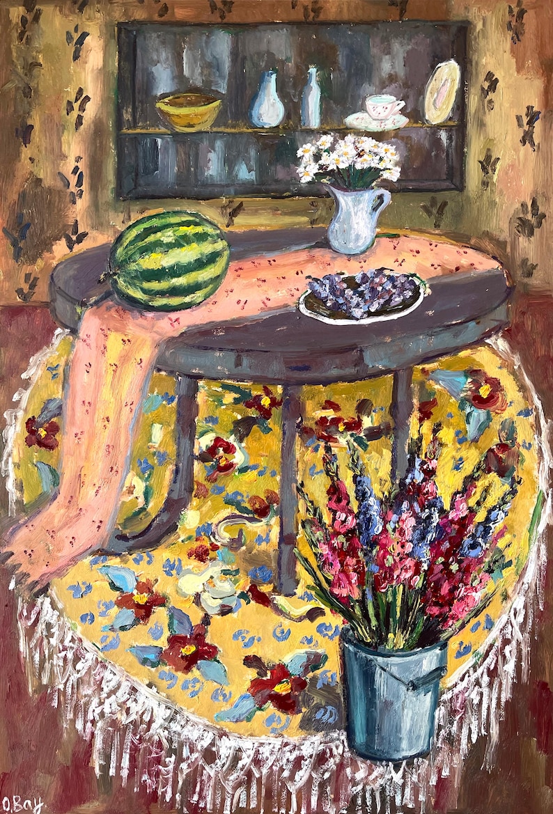 May include: An oil painting depicts a round table with a watermelon, grapes, and flowers. The table is covered with a yellow floral tablecloth and a pink runner. A shelf with vases and a bowl is in the background.