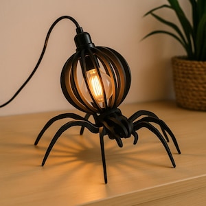 May include: Black spider-shaped table lamp with a caged bulb enclosure. The lamp has six legs and a round bulb cage. The bulb is lit, casting a warm glow. The lamp is on a wooden surface.