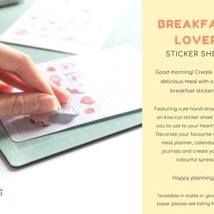 Pu&ograve; includere: Un foglio di adesivi con adorabili illustrazioni disegnate a mano di cibo per la colazione. Il foglio &egrave; bianco con accenti rosa e presenta una variet&agrave; di cibi per la colazione come pancake, uova e caff&egrave;. Il testo "BREAKFAST LOVER STICKER SHEET" &egrave; stampato in arancione e rosa nella parte superiore del foglio.